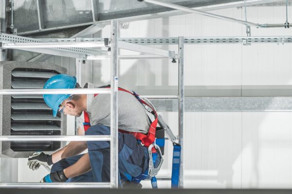 HVAC Worker Checking on Commercial Warehouse Heater HVAC Worker Checking on Commercial Warehouse Heater